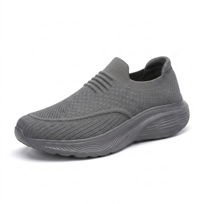 Grå slip-on komfortsko unisex med støtdempende sål og stretchstrikket overdel mot hvit bakgrunn