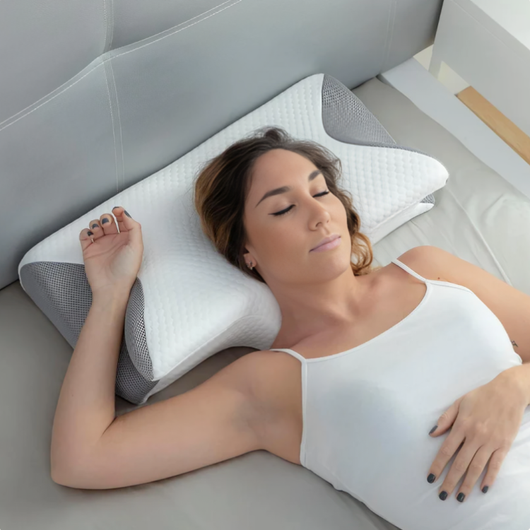 Kvinne som sover på ryggen på ergonomisk minneskumspute med grå meshkanter