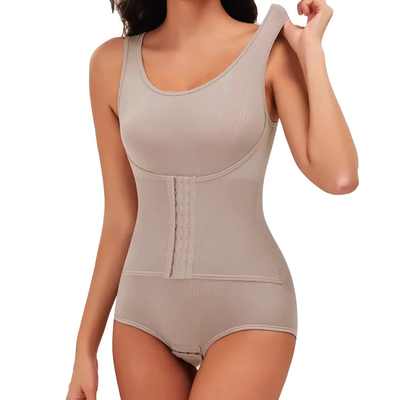 En kvinne justerer skulderstroppen på en beige figurformende body med korsett