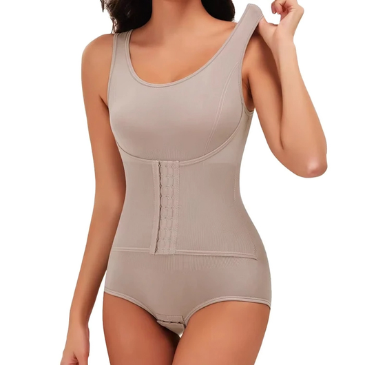 En kvinne justerer skulderstroppen på en beige figurformende body med korsett