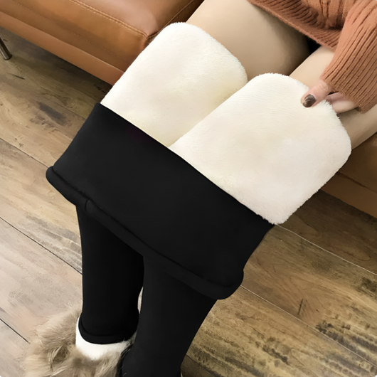 Nærbilde nedenfra av svarte varmeleggings med buksebena brettet opp som viser det hvite fleecefôret